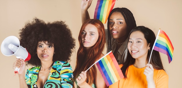 Grupo de mujeres multirraciales, con bandera del orgullo gay lgbt