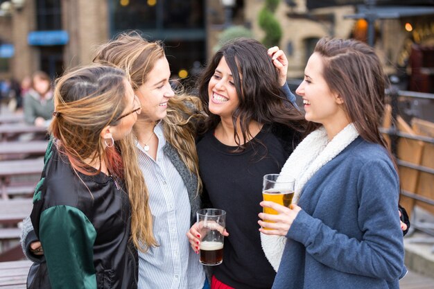 Grupo de mujeres que gozan de una cerveza en el pub en Londres.