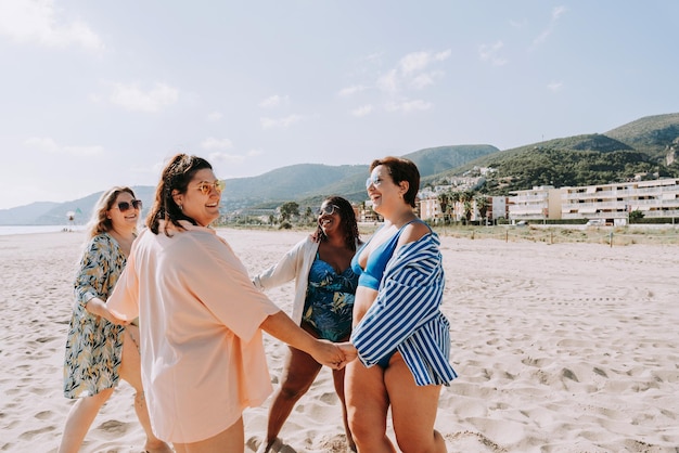 Grupo de mujeres de talla grande con traje de baño en la playa.