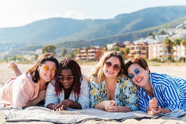 Grupo de mujeres de talla grande con traje de baño en la playa.