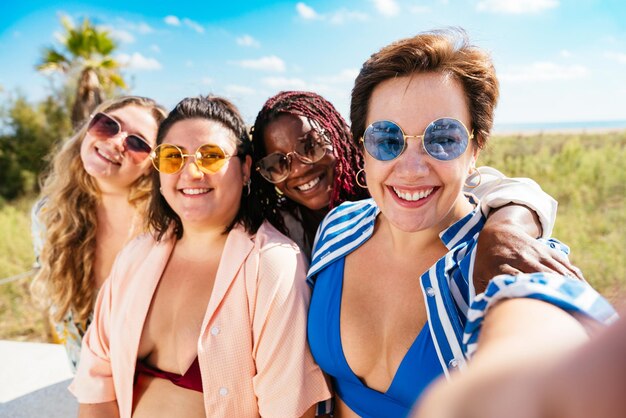 Grupo de mujeres de talla grande con traje de baño en la playa.