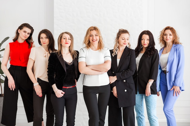 Grupo de mujeres vestidas con estilo empresarial posando y mirando a la cámara.