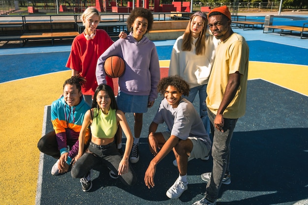 Foto grupo multicultural de jovens amigos se divertindo ao ar livre e se divertindo - adolescentes elegantes e descolados se reunindo no parque urbano de skate