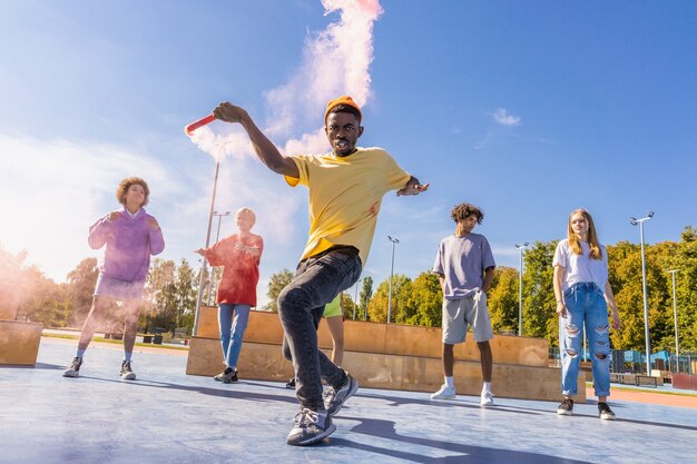 Grupo multicultural de jovens amigos se divertindo ao ar livre e se divertindo - adolescentes elegantes e descolados se reunindo no parque urbano de skate