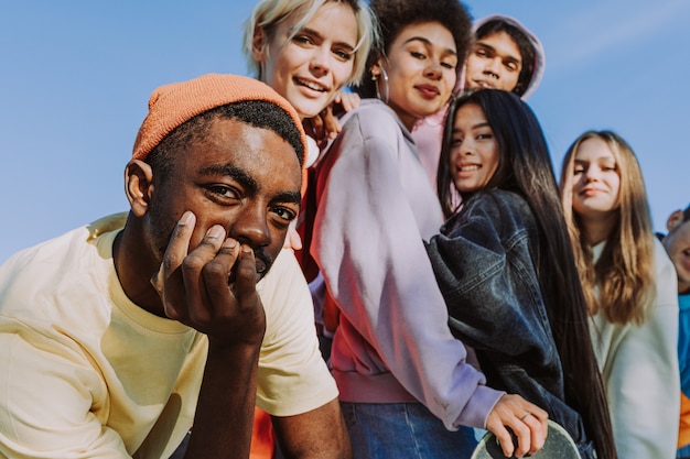 Foto grupo multicultural de jovens amigos se divertindo ao ar livre e se divertindo - adolescentes elegantes e descolados se reunindo no parque urbano de skate