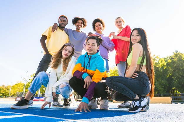 Grupo multicultural de jovens amigos se divertindo ao ar livre e se divertindo - adolescentes elegantes e descolados se reunindo no parque urbano de skate
