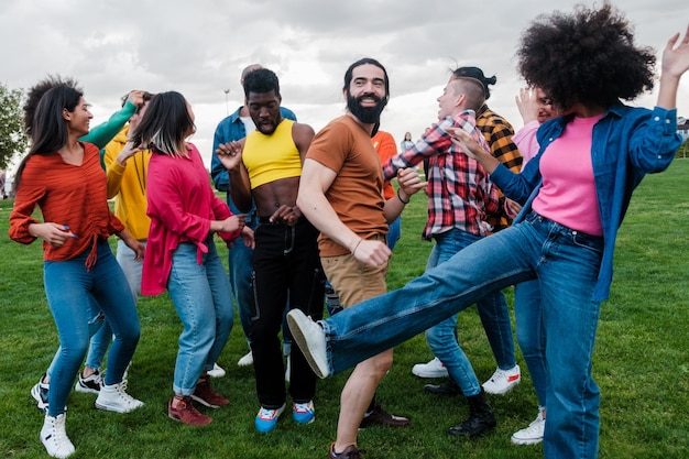 Grupo multicultural de jovens se divertindo dançando ao ar livre