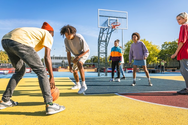 Foto grupo multicultural de jóvenes amigos que se unen al aire libre y se divierten - adolescentes elegantes y geniales reunidos en un parque de patinaje urbano