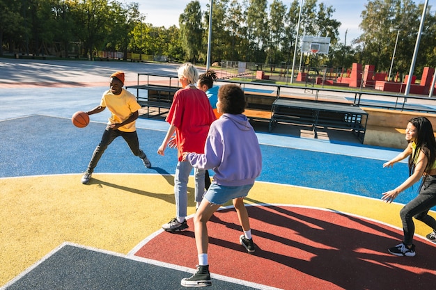 Foto grupo multicultural de jóvenes amigos que se unen al aire libre y se divierten - adolescentes elegantes y geniales reunidos en un parque de patinaje urbano