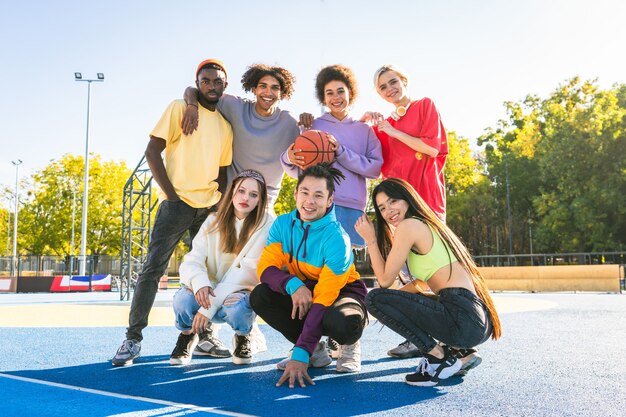 Grupo multicultural de jóvenes amigos que se unen al aire libre y se divierten - Adolescentes elegantes y geniales reunidos en un parque de patinaje urbano