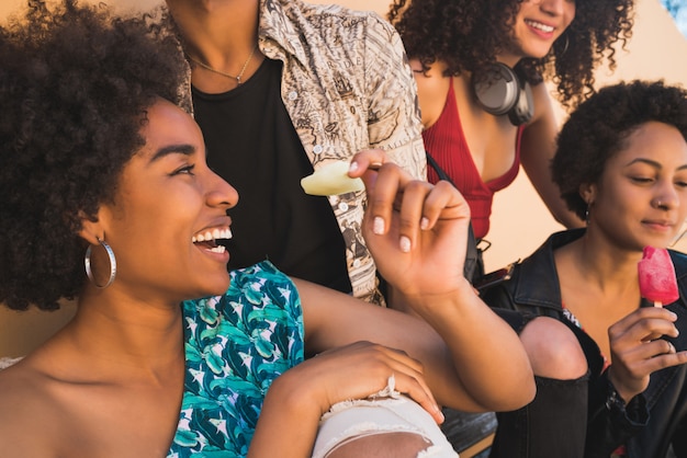 Grupo multiétnico de amigos curtindo o verão enquanto tomam sorvete