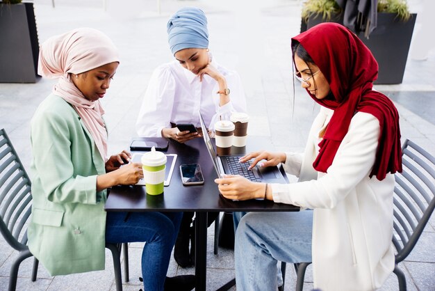 grupo multiétnico de garotas muçulmanas vestindo roupas casuais e o hijab tradicional se relacionando ao ar livre