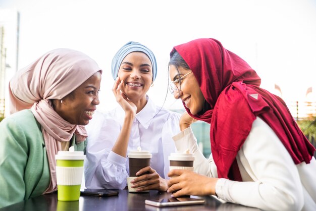 grupo multiétnico de garotas muçulmanas vestindo roupas casuais e o hijab tradicional se relacionando ao ar livre