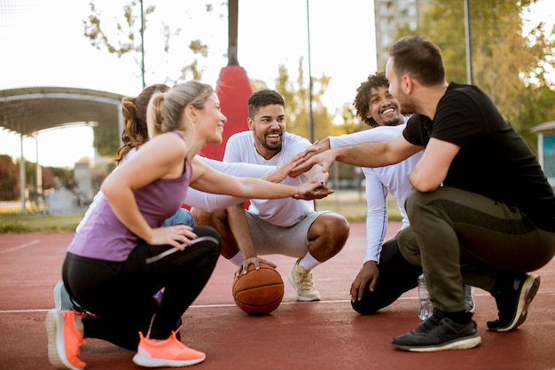 Foto grupo multiétnico de jogadores de basquete descansando na quadra