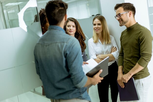 Grupo multiétnico de jovens em pé no escritório moderno e de brainstorming