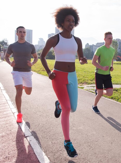 grupo multiétnico de jovens na bela manhã jogging enquanto o sol nasce nas ruas da cidade