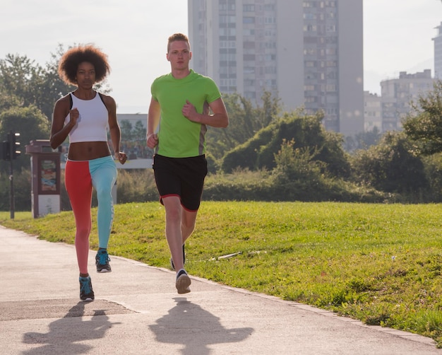 grupo multiétnico de jovens na bela manhã jogging enquanto o sol nasce nas ruas da cidade