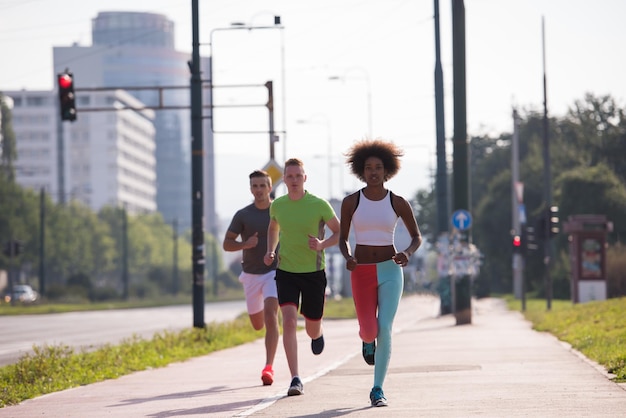 grupo multiétnico de jovens na bela manhã jogging enquanto o sol nasce nas ruas da cidade
