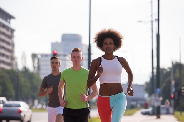 Foto grupo multiétnico de jovens na bela manhã jogging enquanto o sol nasce nas ruas da cidade