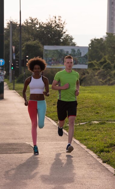 grupo multiétnico de jovens na bela manhã jogging enquanto o sol nasce nas ruas da cidade