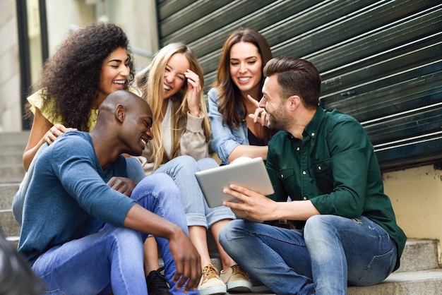 Grupo multiétnico de jovens olhando um tablet computador