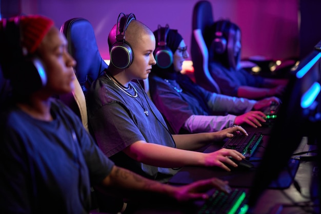 Grupo multiétnico de mulheres jogando videogames em fila como equipe de esportes eletrônicos