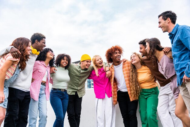 Grupo multiétnico feliz e brincalhão de jovens amigos se unindo ao ar livre