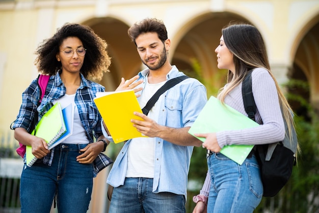 Un grupo multiétnico feliz de estudiantes hablando al aire libre