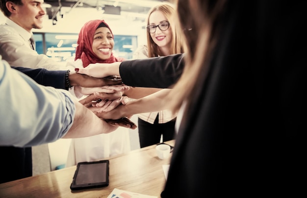 Grupo multiétnico de jóvenes empresarios que celebran el éxito en sus lugares de trabajo en el éxito de la oficina de inicio y el concepto ganador