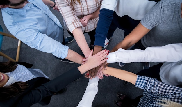 Grupo multiétnico de jóvenes empresarios que celebran el éxito en sus lugares de trabajo en el éxito de la oficina de inicio y el concepto ganador