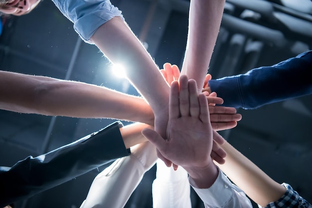 Grupo multiétnico de jóvenes empresarios que celebran el éxito en sus lugares de trabajo en el éxito de la oficina de inicio y el concepto ganador