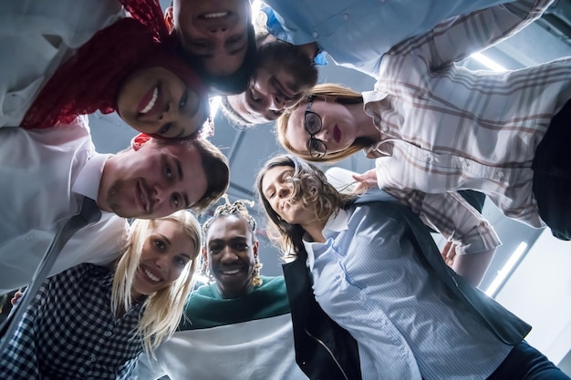 Grupo multiétnico de jóvenes empresarios que celebran el éxito en sus lugares de trabajo en el éxito de la oficina de inicio y el concepto ganador