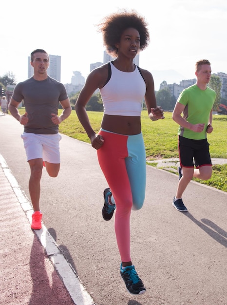 grupo multiétnico de jóvenes en la hermosa mañana de jogging mientras sale el sol en las calles de la ciudad