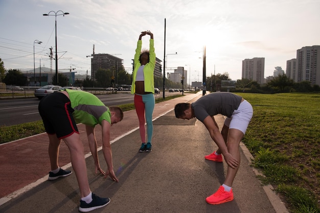 grupo multiétnico de jóvenes en la hermosa mañana de jogging mientras sale el sol en las calles de la ciudad