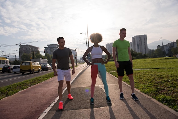 grupo multiétnico de jóvenes en la hermosa mañana de jogging mientras sale el sol en las calles de la ciudad