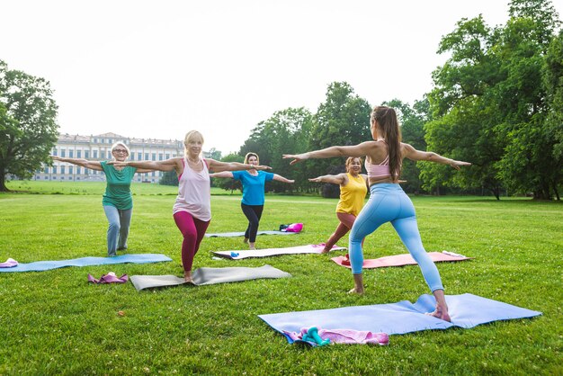 Grupo multiétnico de mujeres mayores entrenando en el parque con instructor de fitness - Ancianos activos haciendo deporte en la naturaleza