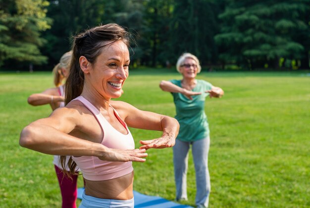 Grupo multiétnico de mujeres mayores entrenando en el parque con instructor de fitness - Ancianos activos haciendo deporte en la naturaleza