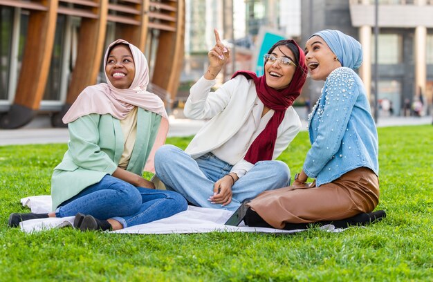 Grupo multiétnico de niñas musulmanas vistiendo ropa casual y tradicional hijab unión al aire libre