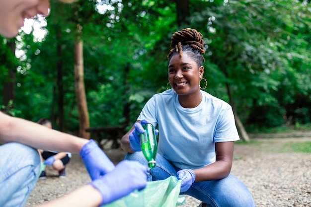 Un grupo multiétnico de personas que limpian juntas en un parque público protegen el medio ambiente El concepto de reciclaje y limpieza