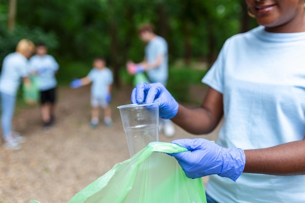 Un grupo multiétnico de personas que limpian juntas en un parque público protegen el medio ambiente El concepto de reciclaje y limpieza