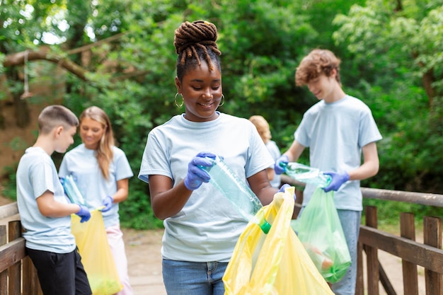 Un grupo multiétnico de personas que limpian juntas en un parque público protegen el medio ambiente El concepto de reciclaje y limpieza