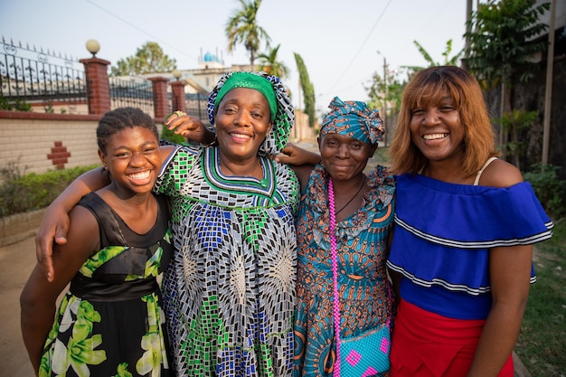 Grupo multigeracional de amigas africanas juntas abraçando e rindo mulheres africanas