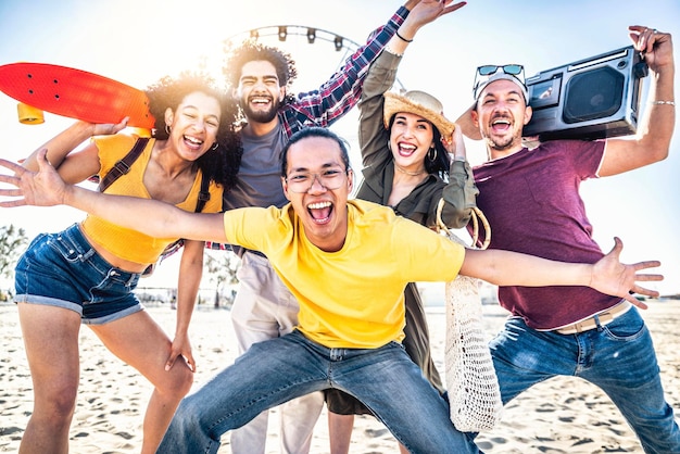 Grupo multirracial de amigos disfrutando de unas vacaciones en una fiesta en la playa