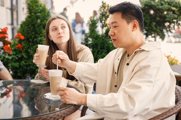 Grupo multirracial de amigos tomando un café juntos en un café al aire libre