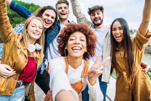 Grupo multirracial de amigos tomando fotos selfie afuera