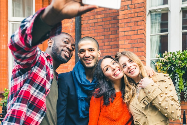 Grupo multirracial de amigos tomando una selfie juntos.