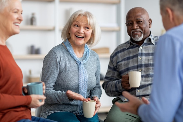 Grupo multirracial de ancianos positivos bebiendo té charlando