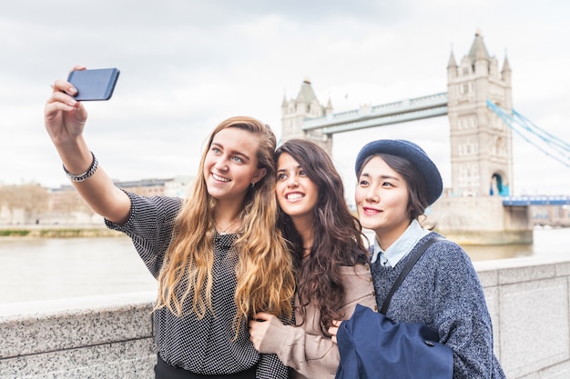 Grupo multirracial de chicas tomando un selfie en Londres.