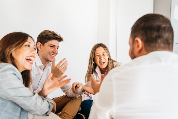 Foto grupo multirracial de compañeros de trabajo riendo juntos.