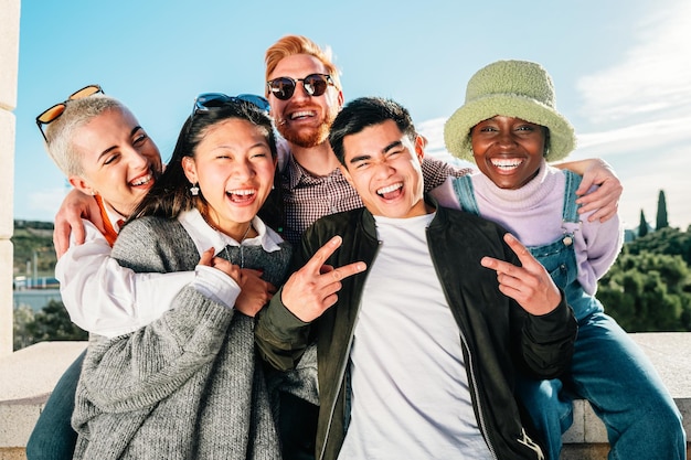 Grupo multirracial de amigos sorrindo posando na frente da câmera para uma foto